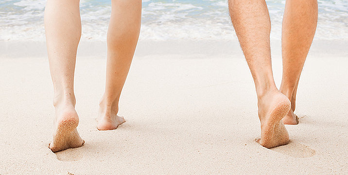 Zwei Menschen gehen am Strand spazieren