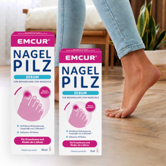Die Füße einer Frau auf Holzboden. Davor die beiden Packungsgrößen des Emcur Nagelpilz-Serum.