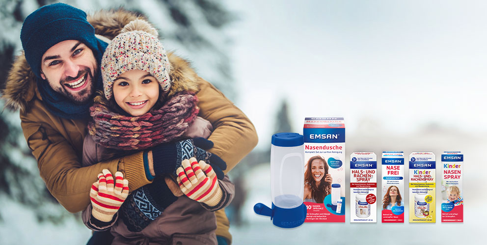 Vater und Tochter lachen im Schnee; daneben einige Produkte von Emsan® zur Anwendung bei Erkältungssymptomen